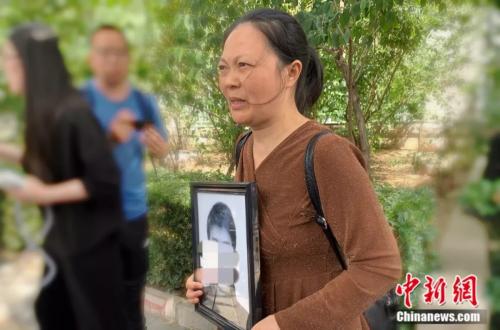 謝雕母親帶著謝雕的遺照走出法院 <a target='_blank' >中新網(wǎng)</a> 楊雨奇 攝 點擊進(jìn)入下一頁